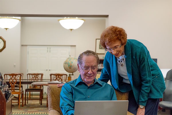 Elderly couple browses the internet, researching senior living options