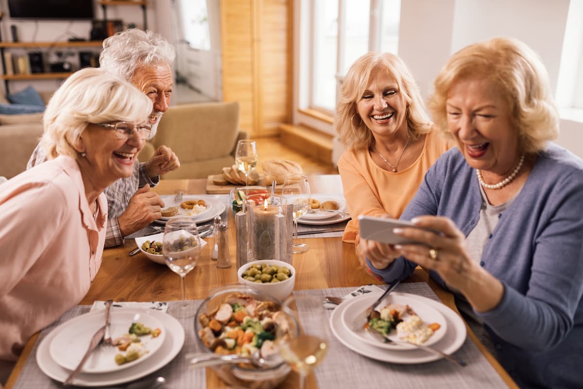 A cheerful group of senior adults enjoys time together at the dinner table