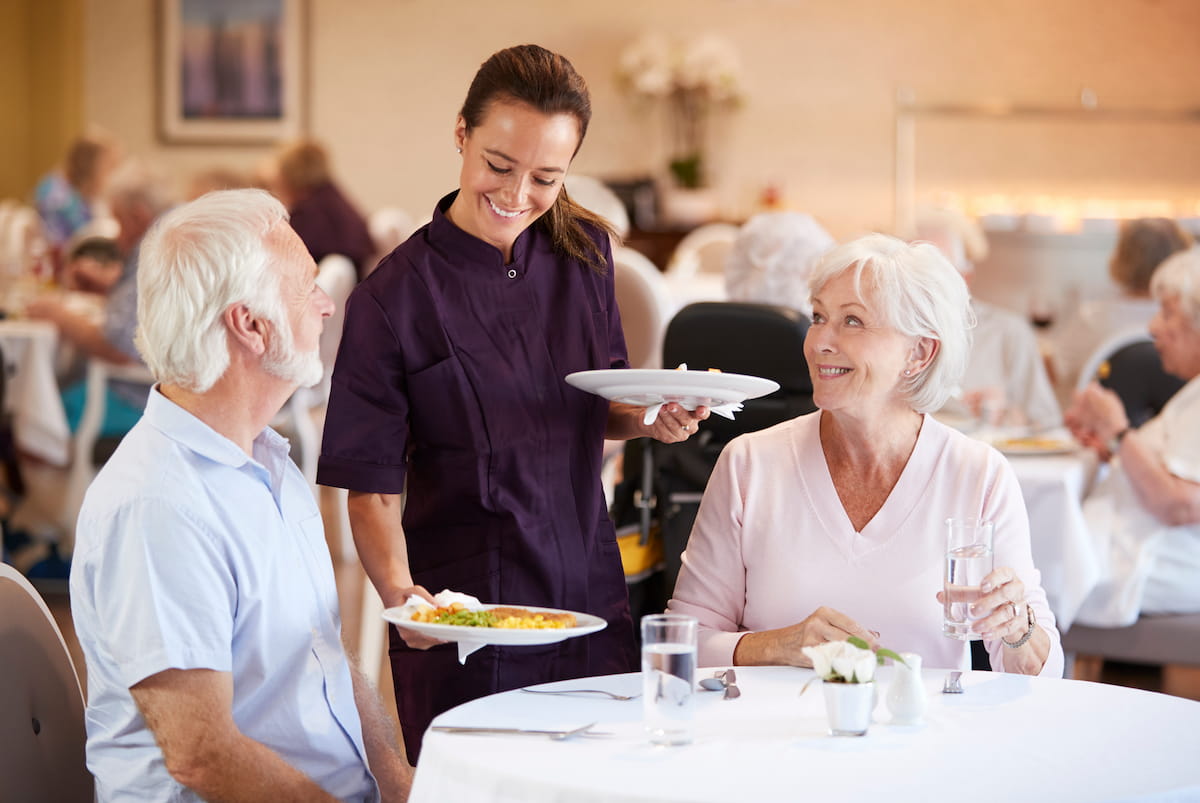 Senior couple being served a meal