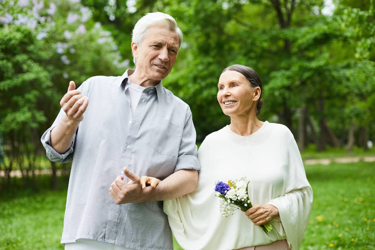 An older couple enjoys a stroll outside together.