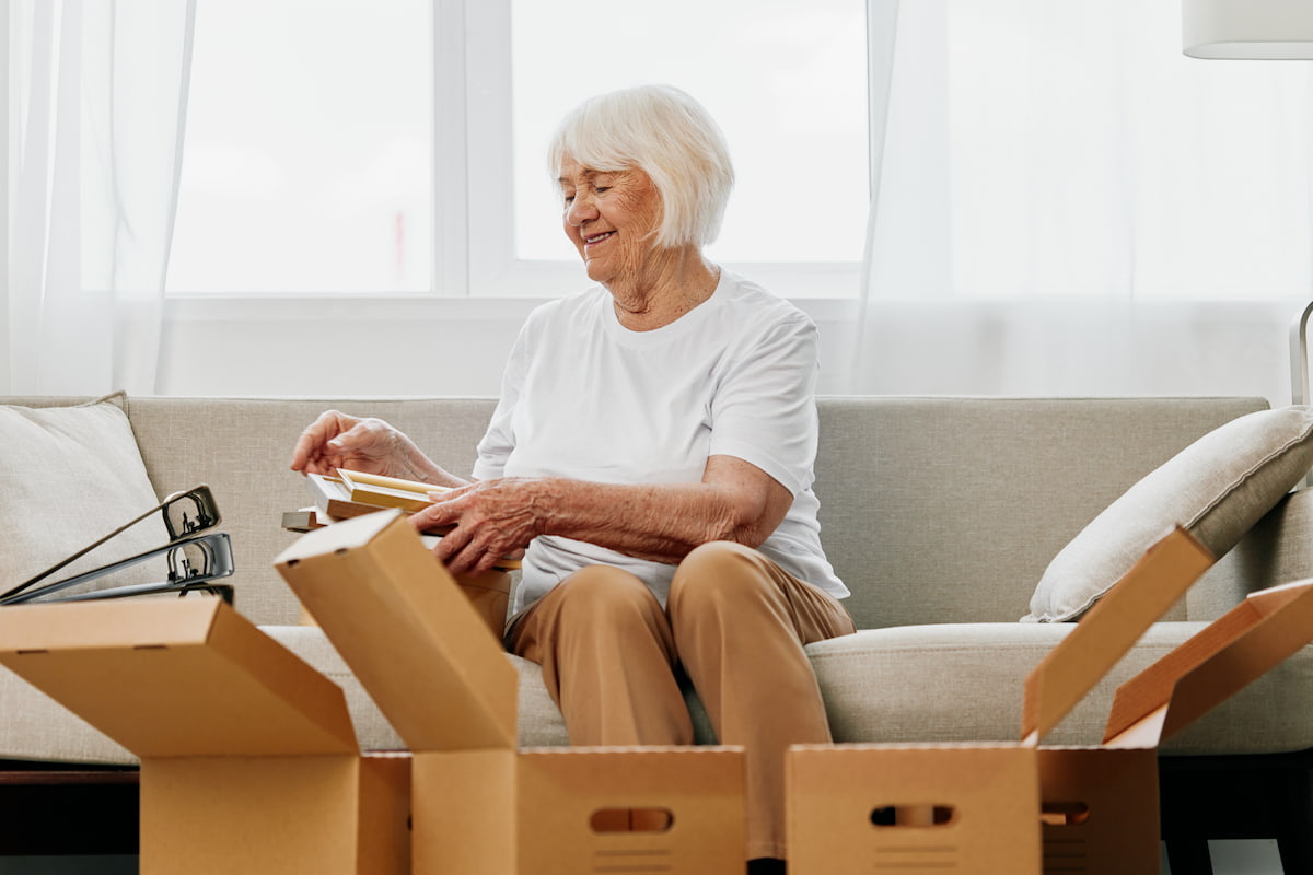 A happy resident packing for a move into independent living