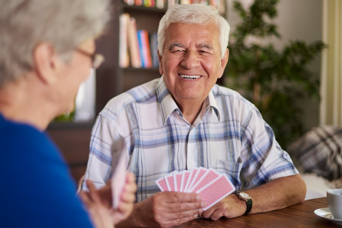An elderly couple enjoys playing a game of cards together